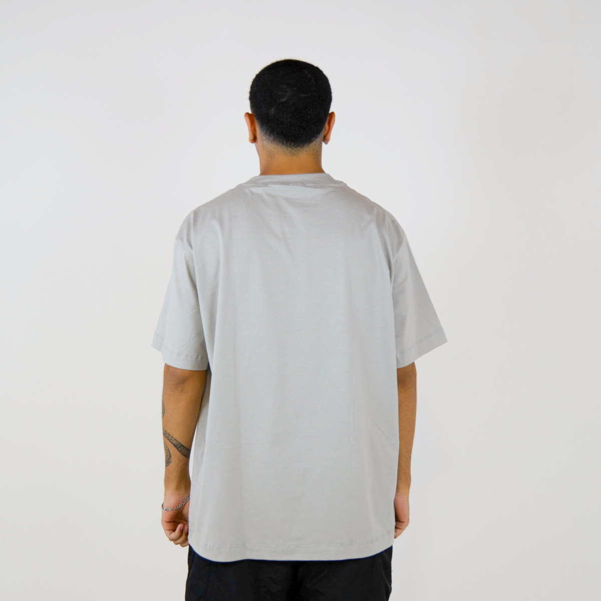Detalhe do ombro caído da camiseta oversized cinza FLEECE